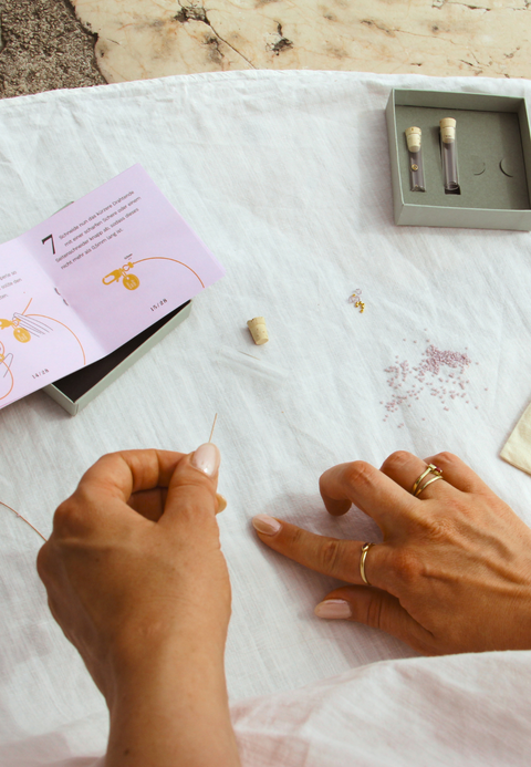 zwei Hände stellen ein Schmuckstück selbst her  aus MIYUKI Glasperlen mit einem ever so tiny Schmuckset