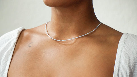 Zarte DIY-Halskette in Hellblau mit goldfarbenen Details und Swarovski-Kristallen, designt für einen minimalistischen und eleganten Look. Getragen zu einem weißen Oberteil, unterstreicht das Schmuckstück aus dem ever so tiny DIY-Set die nachhaltige und hochwertige Gestaltung.