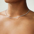 Zarte DIY-Halskette in Hellblau mit goldfarbenen Details und Swarovski-Kristallen, designt für einen minimalistischen und eleganten Look. Getragen zu einem weißen Oberteil, unterstreicht das Schmuckstück aus dem ever so tiny DIY-Set die nachhaltige und hochwertige Gestaltung.